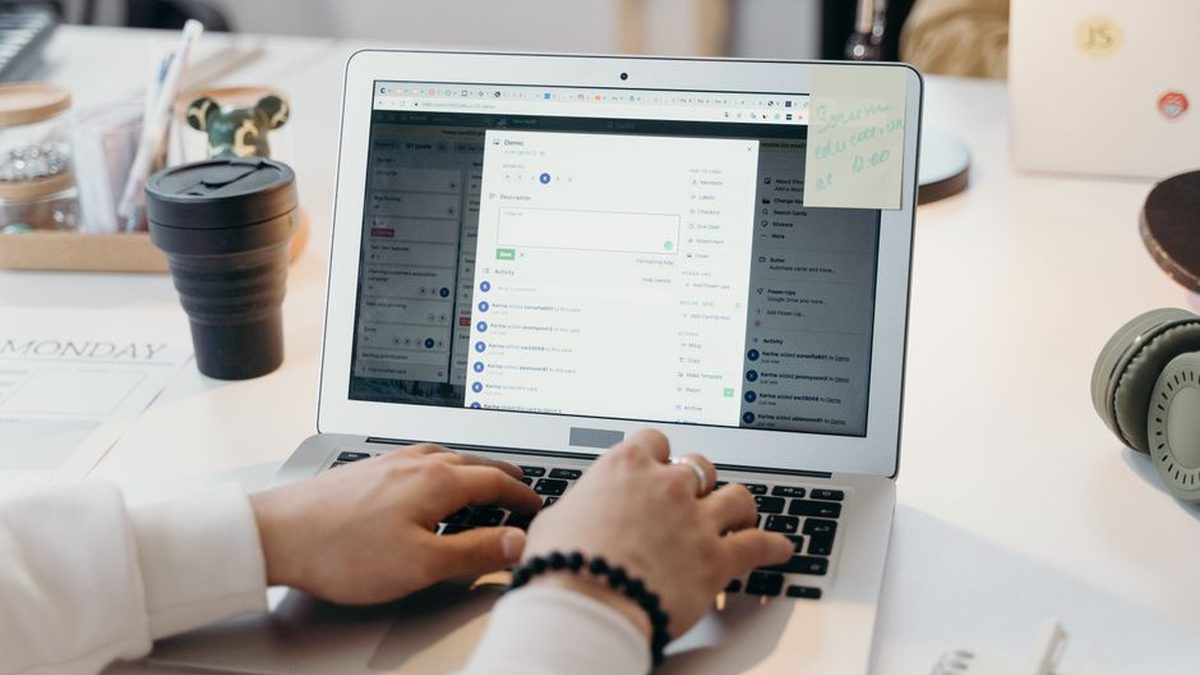 Kahve ve not defteriyle birlikte laptopta yazışma yapan eller